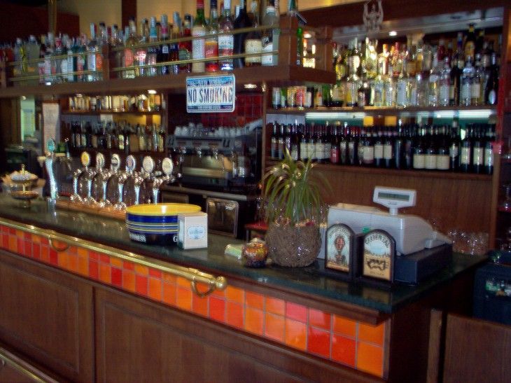 Il bancone del bar con le bottiglie sugli scaffali