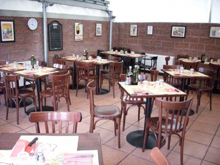 Seconda sala con pareti in mattoni e tavoli apparecchiati