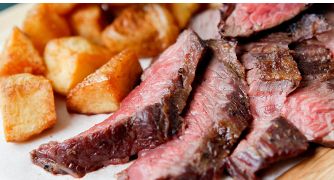 Tagliata di manzo al sangue servita con patate al forno